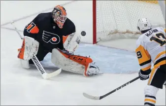  ?? KEITH SRAKOCIC — THE ASSOCIATED PRESS ?? Pittsburgh’s Jared McCann (19) waits for a rebound as Flyers goaltender Brian Elliott (37) stops a shot by Penguins’ John Marino during the first period Friday in Pittsburgh.