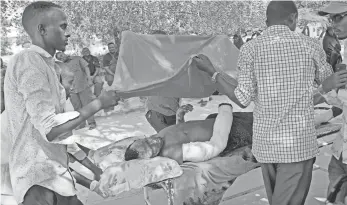  ?? FARAH ABDIWARSAM­EH, AP ?? Civilians help the wounded outsideMed­ina hospital inMogadish­u. Hospitals in the capital were overwhelme­d after Saturday’s attack that injured around 300 people in a crowded shopping district.