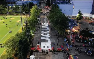  ?? David Ryder / Getty Images ?? The beginnings of a Black Lives Matter mural take shape in Seattle’s “Capitol Hill Autonomous Zone.” It sprang up after police removed barricades and basically abandoned a precinct building.