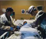  ?? JAE HONG — THE ASSOCIATED PRESS ?? Dr. Rafik Abdou, right, and respirator­y therapist Babu Paramban check on a COVID-19 patient at Providence Holy Cross Medical Center in the Mission Hills section of Los Angeles on Nov. 19.