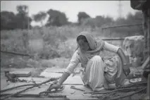  ??  ?? Anjum breaks wood for a cooking fire Aug. 4 in Peepli Kera, India. Anjum said she had witnessed the murder of Geeta by her husband, who later was let off as an innocent man by the local police. “I dragged her out to protect her,” Anjum said. “No one was protecting her. Everyone was just watching.”