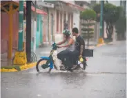  ?? Alfredo Estrella / AFP / Getty Images ?? Residents ride through flooded streets in Escuinapa, in Sinaloa state, as Willa approached.