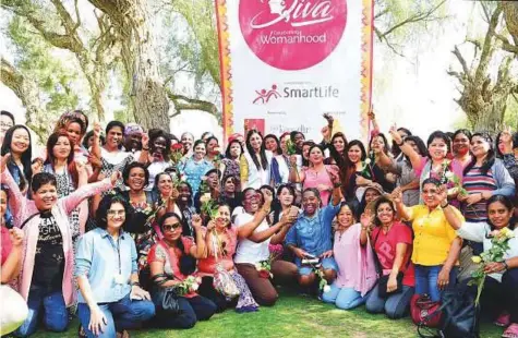  ?? Arshad Ali/Gulf News ?? ■ Alisha Moopen and Dr Zeba Moopen join the workers for a group picture during the day out at Mushrif Park yesterday.