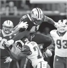  ?? Associated Press ?? ■ New Orleans Saints running back Alvin Kamara (41) leaps over Los Angeles Rams free safety Lamarcus Joyner (20) on a rushing play Sunday in the second half of an NFL game in New Orleans.