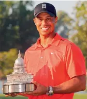  ?? — AFP ?? Tiger Woods poses with the trophy after winning the AT&T National at Congressio­nal Country Club in Bethesda, Maryland, USA, on Sunday.