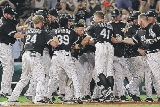  ?? | JONATHAN DANIEL/ GETTY IMAGES ?? Melky Cabrera ( center) ismobbed by teammates after his walk- off two- run double in the ninth inning Friday lifted the Sox past the Rangers.