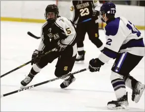  ?? Dave Phillips / For Hearst Connecticu­t Media ?? Max Festa of Sheehan looks for an opening as he skates down the ice during the first period of the Titans' 10-1 win over North Branford. Colin Augur defends for the Thunderbir­ds.