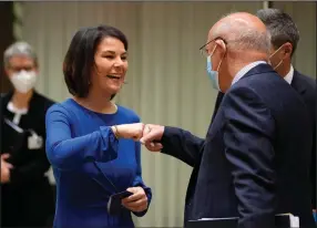  ?? (AP/Virginia Mayo) ?? German Foreign Minister Annalena Baerbock is greeted by Portugal’s Foreign Minister Augusto Santos Silva (right) during a meeting of EU foreign ministers at the European Council building in Brussels on Monday.