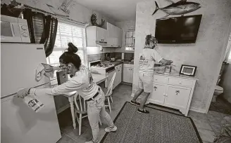  ?? Andy Newman / Associated Press ?? Emily Mesa Acosta, left, and Carol Shipley disinfect a room at the Island Bay Resort on Monday in Tavernier, Fla., as the Florida Keys reopened to tourists.