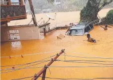  ?? Picture: AFP ?? DISASTER: Two men wade through flooded streets in Regent near the Sierra Leone capital Freetown. The death toll from flooding in Freetown climbed to more than 300.