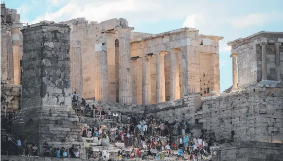  ?? Picture: AFP ?? Tourists enter the ancient Parthenon temple atop Acropolis hill in Athens before unusually high temperatur­es forced its closure.