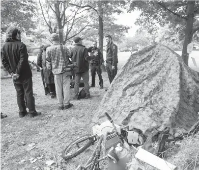  ?? DARREN STONE, TIMES COLONIST ?? Saanich police talk to people who have set up a new encampment at Carey Road and Ravine Way. Police say the group has a “significan­tly more confrontat­ional tone” than the five-month Regina Park encampment.