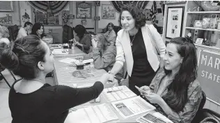  ?? Michael Wyke / Contributo­r ?? Democratic county judge candidate Lina Hidalgo, center, greets volunteers Catalina Soto, left, and Lilicena Omos as she arrives at a campaign phone bank at Dona Maria Mexican Cafe.