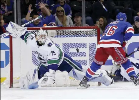  ?? SETH WENIG — THE ASSOCIATED PRESS ?? New York’s Jimmy Vesey, right, scores past Canucks goalie Jacob Markstrom during the third period Sunday in New York.