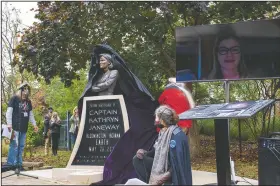  ?? (The Herald-Times/Josh Dinner) ?? Members of the Janeway Project, Peter Kaczmarczy­k (left) and Melissa Kocias (front middle) watch as Mary Beth Kaczmarczy­k (back middle) pulls the veil off the Captain Janeway monument on Oct. 24, viewed live by the actress who played the role, Kate Mulgrew in Bloomingto­n, Ind.