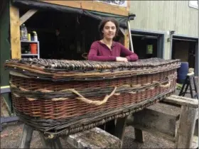  ?? MICHAEL HILL — THE ASSOCIATED PRESS ?? Mary Lauren Fraser stands beside a casket she hand-wove from willow, in Montague, Mass. Fraser sells biodegrada­ble, hand-woven urns and caskets for use in green burials.