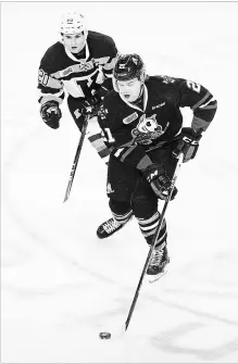  ?? JULIE JOCSAK THE ST. CATHARINES STANDARD ?? Niagara’s Matt Brassard, foreground, is pursued by former IceDog Ian Martin in Ontario Hockey League action versus Kingston on Friday night at Meridian Centre in St. Catharines. Brassard is among the newcomers to the team.