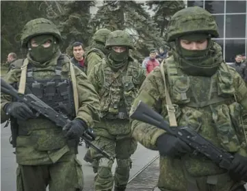  ?? SERGEY PONOMAREV/THE NEW YORK TIMES ?? Soldiers patrol at an airport in Crimea, a region illegally annexed by Russia in 2014.