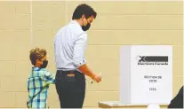  ?? SEAN KILPATRICK/CANADIAN PRESS ?? Justin Trudeau votes with the help of son Hadrien in Papineau yesterday.