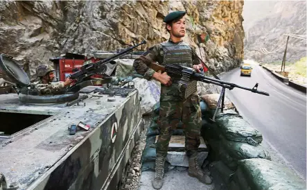 ??  ?? nner on atch Afghanista­n. — AP An Afghan soldier guarding a checkpoint on the Kabul-Jalalabad highway on the outskirts of Kabul,
