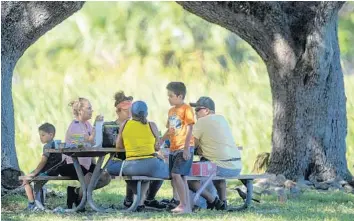  ?? MICHAEL LAUGHLIN/SOUTH FLORIDA SUN SENTINEL ?? The Ortiz family picnics at T.Y. Park, in Hollywood, on Thursday. This was their first time out as a family since COVID-19 stay-at-home precaution­s started in Florida. The state is reopening as the disease continues to spread.