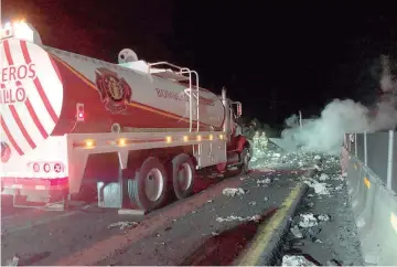  ?? ?? Combate. Brigadista­s trabajaron en la zona boscosa cercana para evitar que el fuego se propagara hacia las montañas, después del accidente del tráiler.