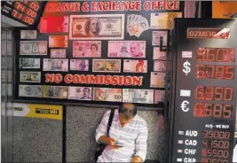  ?? Lefteris Pitarakis ?? The Associated Press A man uses his mobile phone as he sits in a currency exchange shop Thursday in Istanbul. Beset by a weak currency and tension with the United States, Turkey is reaching out to Europe in an attempt to shore up relations with trading partners.