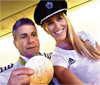  ??  ?? My turn! Helen Glover lets a crew member wear her medal as she tries on his cap