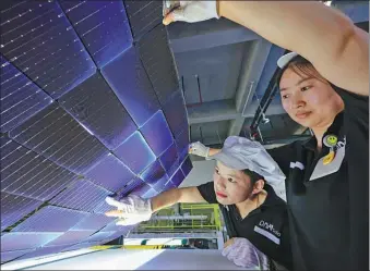  ?? ZHAO MING / FOR CHINA DAILY ?? Employees check solar panels at a new energy technology company in Hefei, Anhui province.