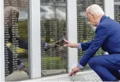  ?? ALEX BRANDON / ASSOCIATED PRESS ?? President Joe Biden reaches to touch the name of his uncle Ambrose J. Finnegan Jr. on a wall at a Scranton war memorial in Scranton, Pa., on Wednesday. His uncle died in WWII.