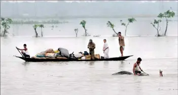  ??  ?? A mahout moves an elephant to higher ground as villagers padddle with their belongings through flood waters in the Pobitora Wildlife Sanctuary, some 55 kms from Guwahati, the capital city of the northeaste­rn state of Assam on June 28, 2012