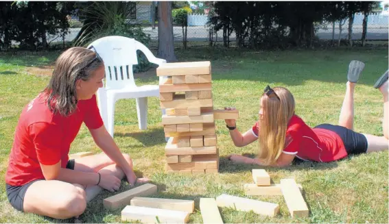  ?? ?? Birthday and swim instructor­s Kaila Van In (left) and Ella Coulton playing a game of Jenga.