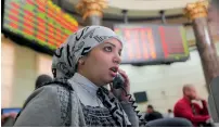  ??  ?? — AP An Egyptian trader monitors her screen at the stock market in Cairo. The Egyptian stocks dropped most in the world on Monday after the central bank raised interest rates to contain prices.