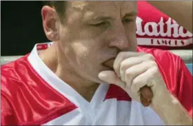  ?? THE ASSOCIATED PRESS ?? Reigning champion Joey Chestnut eats two hot dogs at a time during the men’s competitio­n of the Nathan’s Famous Fourth of July hot dog eating contest, Wednesday in New York’s Coney Island.