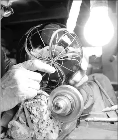  ??  ?? Toshio Takizawa engraves a piece of glass on a rotating wheel at his workshop in Koto Ward, Tokyo. — Japan News-Yomiuri photos