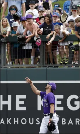  ?? CHRIS CODUTO — GETTY IMAGES ?? Kris Bryant tosses a ball to fans before the third inning of a spring training game between the Rockies and the Brewers at Salt River Fields at Talking Stick on Tuesday in Scottsdale, Ariz.