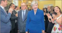  ??  ?? Britain's PM Theresa May is applauded by staff as she returns to 10 Downing Street, after seeking permission from Queen Elizabeth to form a new government, in London on Friday.