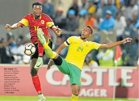  ?? Gallo Images ?? Hot match: SA’s Diamond Thopola is blocked by Natael Masuekama of Angola during the internatio­nal friendly match between SA and Angola at Buffalo City Stadium in East London on Tuesday. /