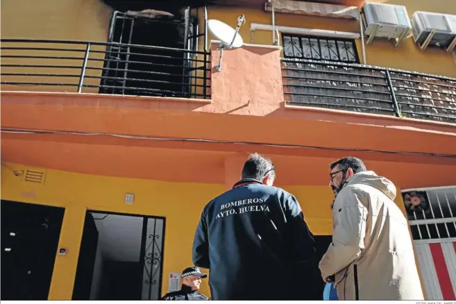  ?? FOTOS: RAFA DEL BARRIO ?? El concejal de Seguridad Ciudadana de Huelva, Luis Albillo, departe con personal de Bomberos y Policía Local pocas horas después del fuego ante la vivienda siniestrad­a.