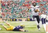  ?? MICHAEL HICKEY GETTY IMAGES ?? Desmond Ridder (9) of Cincinnati scores a TD in the fourth quarter of the Bearcats’ win at South Bend.