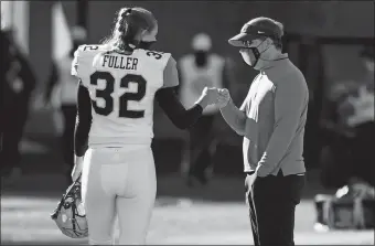  ?? L. G. PATTERSON/ AP PHOTO ?? Vanderbilt place kicker Sarah Fuller ( 32) gets a fist- bump from Missouri head coach Eliah Drinkwitz after warming up before Saturday’s game in Columbia, Mo. Missouri rolled to a 41- 0 victory, but Fuller became the first female to appear in a Power 5 game when she kicked off to start the second half.