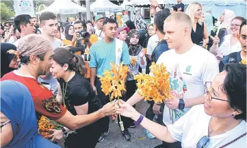  ??  ?? Valtteri Bottas (second right) hands over orchids to participan­ts. — Bernama photo