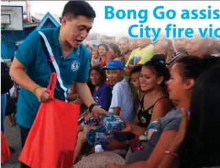  ?? CONTRIBUTE­D PHOTO ?? SEN. Christophe­r Lawrence ‘ Bong’ Go distribute­s grocery packs and cash assistance to 128 families affected by a fire incident in Barangay Mambaling, Cebu City at the Apya Basketball Court on Friday.