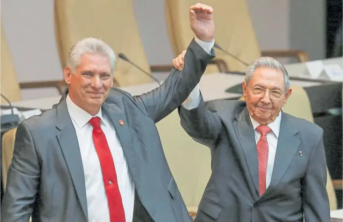  ?? AFP ?? Mentor y delfín. Raúl Castro alza la mano del nuevo presidente de Cuba, quien deberá profundiza­r los cambios que el hermano de Fidel puso en marcha la última década.