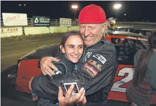  ??  ?? Joe Bellm, right, hugs his daughter Layne Bellm, 14, after she won her first Hobby Stock track championsh­ip and rookie of the year at the El Paso County Raceway this month.