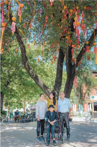  ?? VALÉRIAN MAZATAUD LE DEVOIR ?? L’artiste Karen Tam avec sa famille devant L’arbre à souhaits (2021), à la place des Souhaits, à Montréal. Comme pour d’autres créations de l’artiste qui puisent dans la culture chinoise, ses parents y ont mis du leur ; la mère à la calligraph­ie, le père pour l’assemblage et la grand-mère en tant que muse.