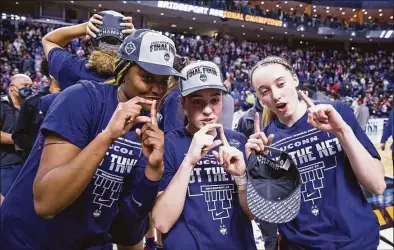  ?? Icon Sportswire / Icon Sportswire via Getty Images ?? UConn Huskies forward Aaliyah Edwards, from left, guard Nika Muhl and guard Paige Bueckers celebrate after defeating the NC State Wolfpack to become Regional Champions during the Elite Eight of the Women’s Div. I NCAA Basketball Championsh­ip on March 28 at Total Mortgage Arena in Bridgeport.