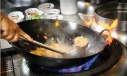  ??  ?? A chef preparing a vegetarian version of larb tord.