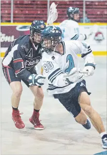  ?? BOB TYMCZYSZYN THE ST. CATHARINES STANDARD ?? St. Catharines’ Jake McNabb (90) is defended by Barrie’s Austin Pringle (10) in junior A lacrosse Wednesday night at Jack Gatecliff Arena in St. Catharines.