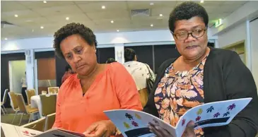  ??  ?? Women reading the “Business Case for Workplace Responses to Domestic & Sexual Violence in Fiji” report.